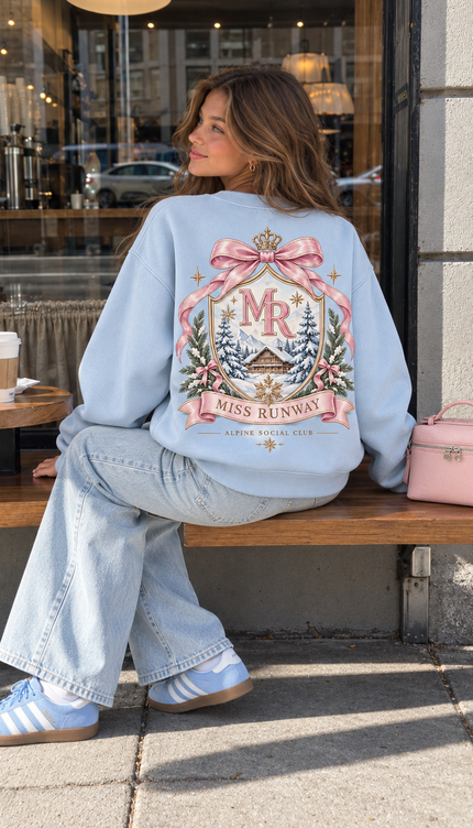 Back of the Alpine Social Club kids' sweatshirt in baby blue with a pastel MR crest, crown and pink bow