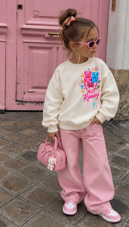 Front of the Gummy Bear Dreams kids' sweatshirt in cream with pink and blue gummy bears with a bow and Miss Runway script on the chest – Miss Runway