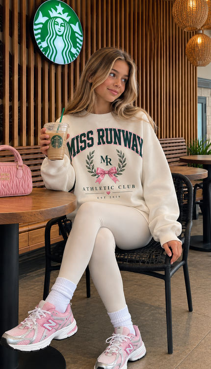 Front of the Preppy Social Club kids' sweatshirt in cream with navy MISS RUNWAY lettering with an MR laurel crest and a pink bow – Miss Runway