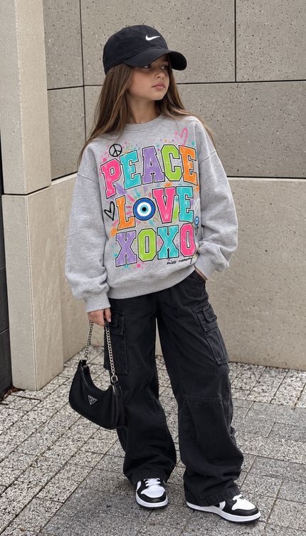 Girl wearing the Pastel Peace Love XOXO Sweatshirt in grey with a rainbow peace, love and xoxo print by Miss Runway