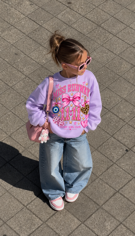 Girl wearing the Lucky Girl Club Sweatshirt in lilac with a lucky girl, evil eye and 11:11 print by Miss Runway