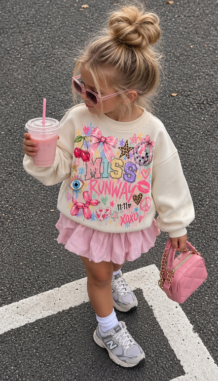 Girl wearing the Pastel Pop Graffiti Sweatshirt in cream with a pastel graffiti print by Miss Runway