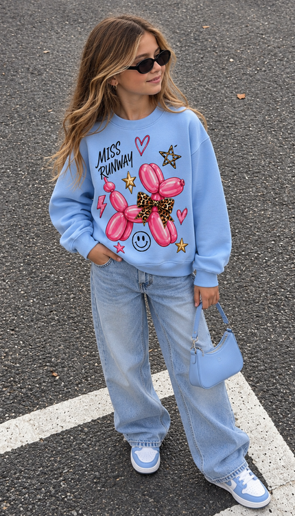 Girl wearing the Leopard Bow Balloon Dog Sweatshirt in light blue with a leopard bow balloon dog print by Miss Runway