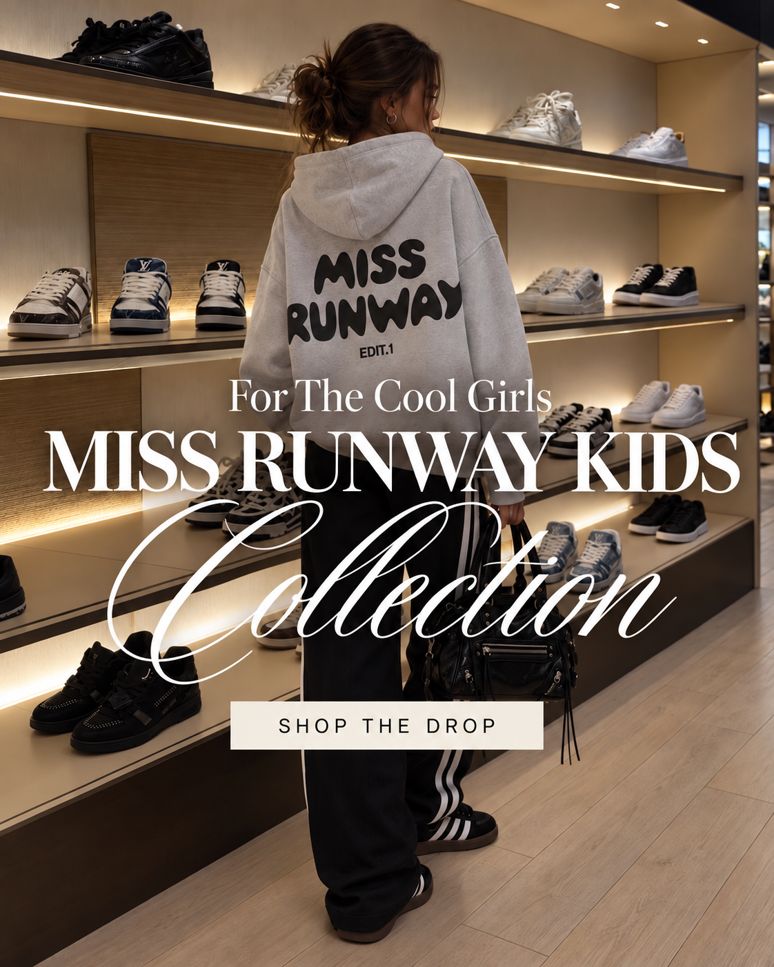 For the cool girls: Miss Runway Kids Collection. Girl in a grey Miss Runway hoodie and black track pants. Shop the drop.