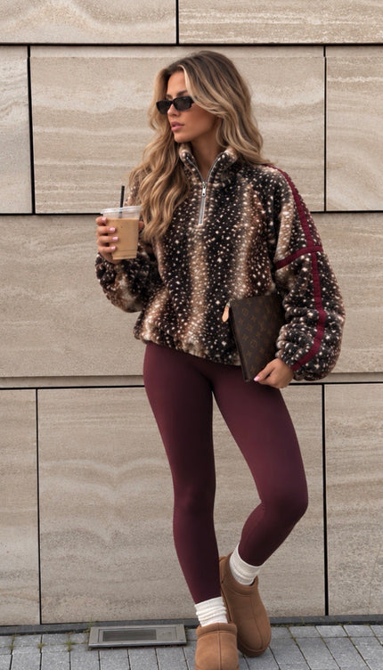 Woman wearing the Deer Print Lightweight Zip-Neck Fleece Burgundy, a half-zip fleece in chocolate and cream deer print with burgundy sleeve stripes, by Miss Runway