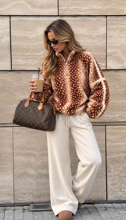 Woman wearing the Deer Print Lightweight Zip-Neck Fleece Cream, a half-zip fleece in chestnut and cream deer print with cream sleeve stripes, by Miss Runway